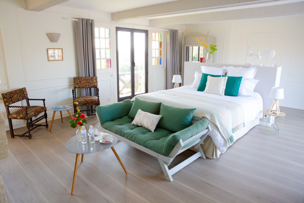 Mittelgroßes Hauptschlafzimmer mit weißer Wandfarbe, braunem Holzboden und braunem Boden in Le Havre