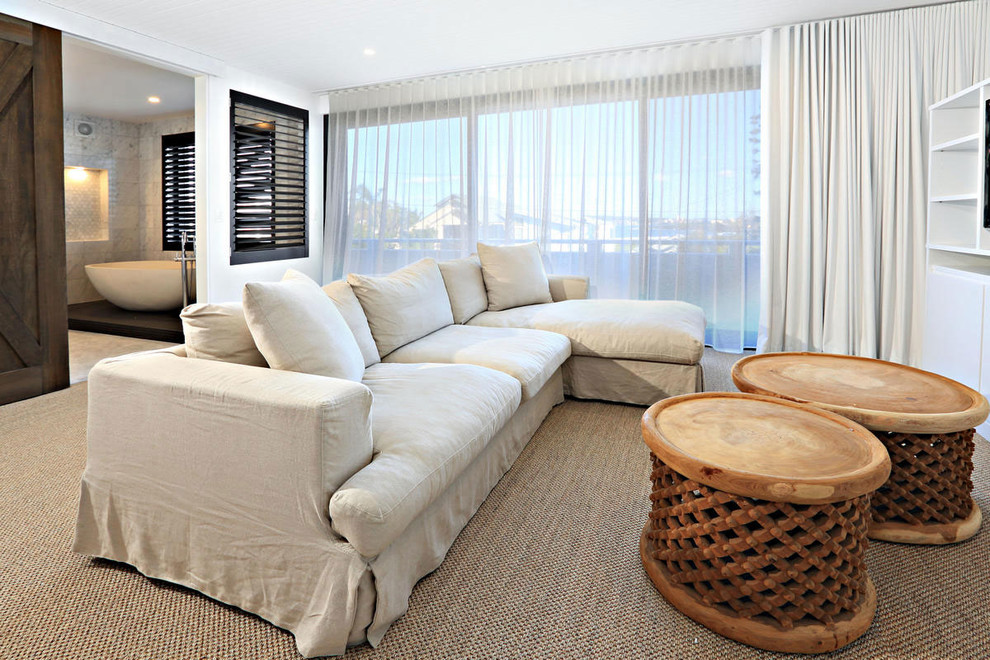 Large modern guest bedroom in Sydney with white walls and carpet.