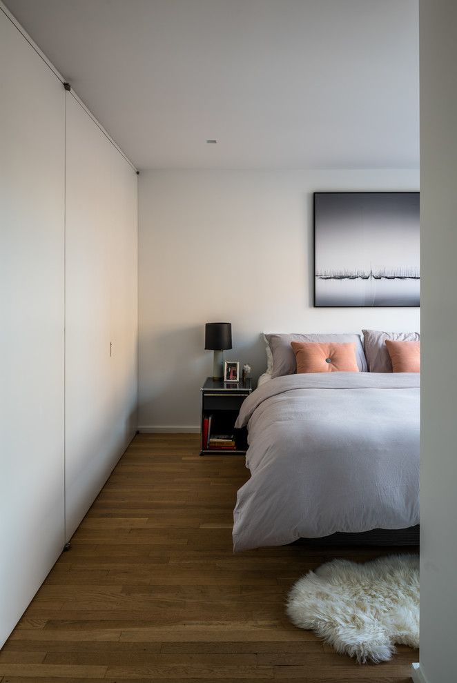 Imagen de dormitorio principal minimalista pequeño con paredes blancas y suelo de madera clara