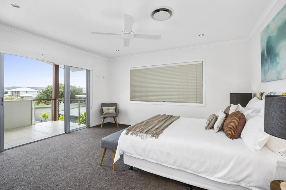 This is an example of a medium sized coastal master bedroom in Gold Coast - Tweed with white walls, carpet and grey floors.
