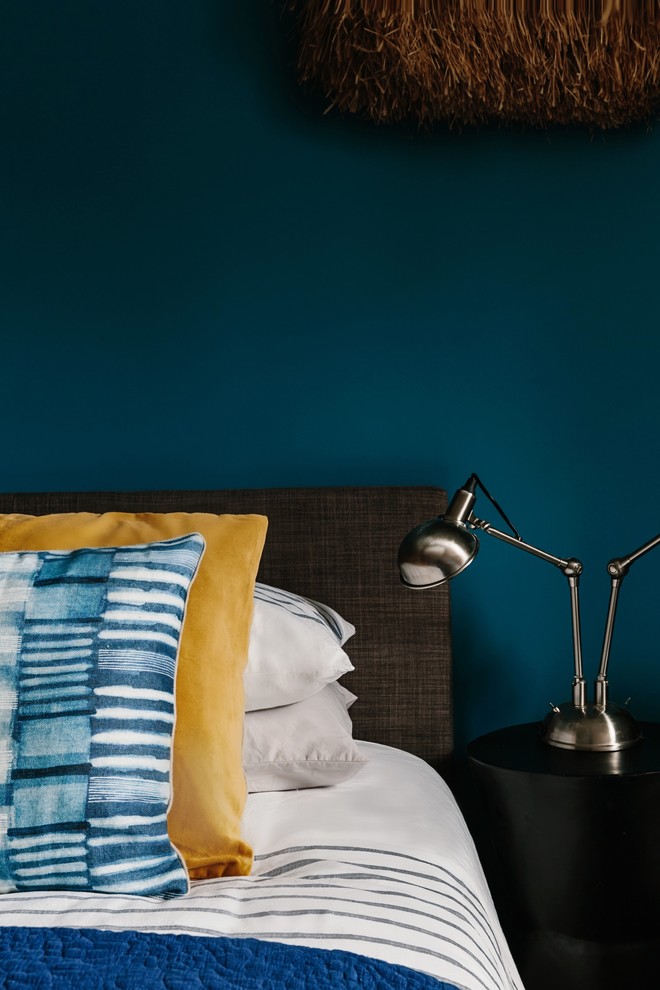 Inspiration pour une chambre d'amis design de taille moyenne avec un mur bleu et parquet clair.