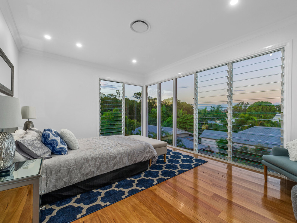 Mittelgroßes Klassisches Schlafzimmer mit weißer Wandfarbe, braunem Holzboden und braunem Boden in Brisbane
