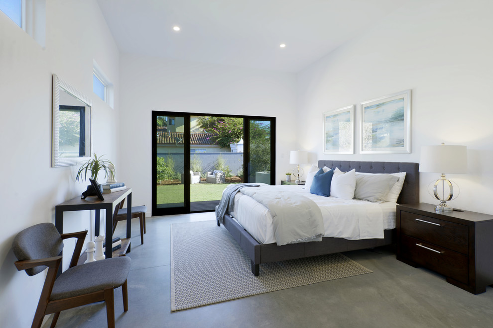 Imagen de dormitorio principal actual con paredes blancas, suelo de cemento y suelo gris
