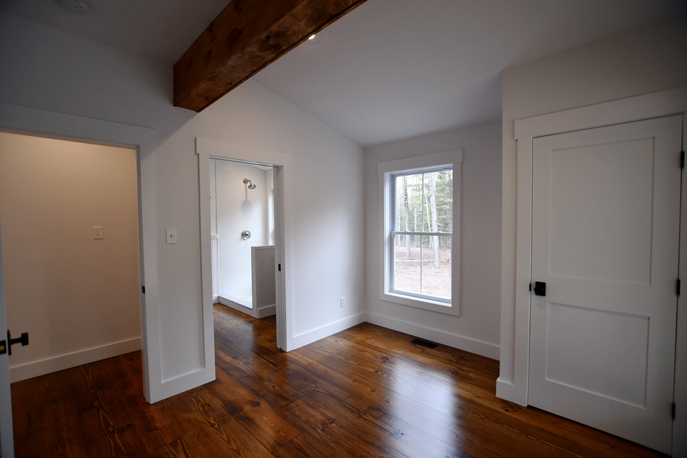 Photo of a medium sized farmhouse guest bedroom in New York with white walls, medium hardwood flooring and brown floors.