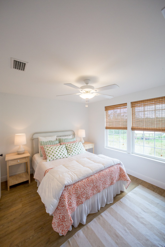 中くらいなカントリー風のおしゃれな客用寝室 (白い壁、コルクフローリング、暖炉なし、茶色い床)