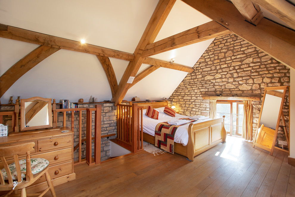 Inspiration for a large rustic mezzanine bedroom in Other with white walls, light hardwood flooring and beige floors.
