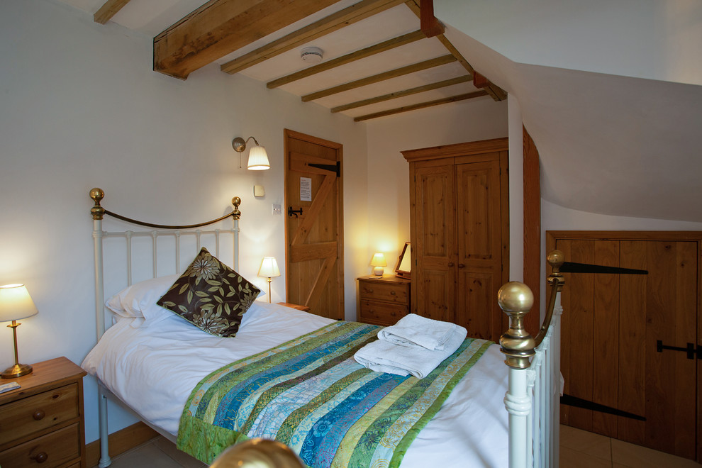 Imagen de habitación de invitados rural de tamaño medio con paredes beige, suelo de baldosas de cerámica y suelo beige