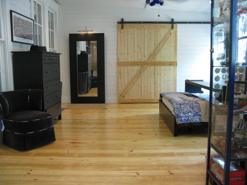 Bohemian loft bedroom in Austin with white walls and medium hardwood flooring.