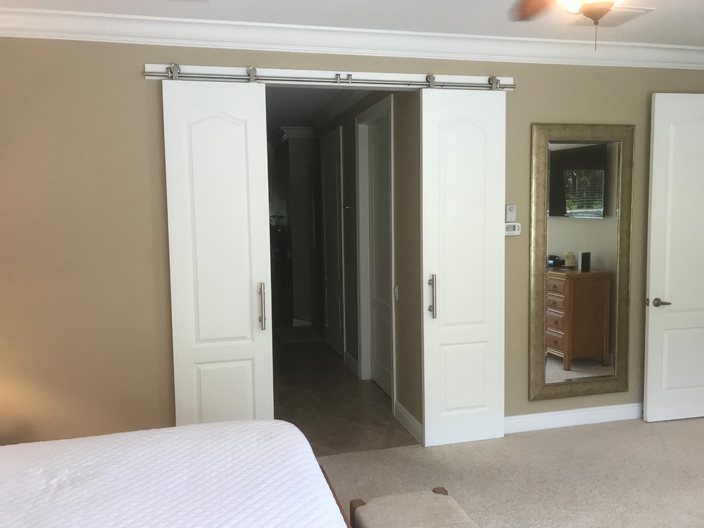 Ejemplo de dormitorio principal actual con paredes beige, moqueta y suelo beige