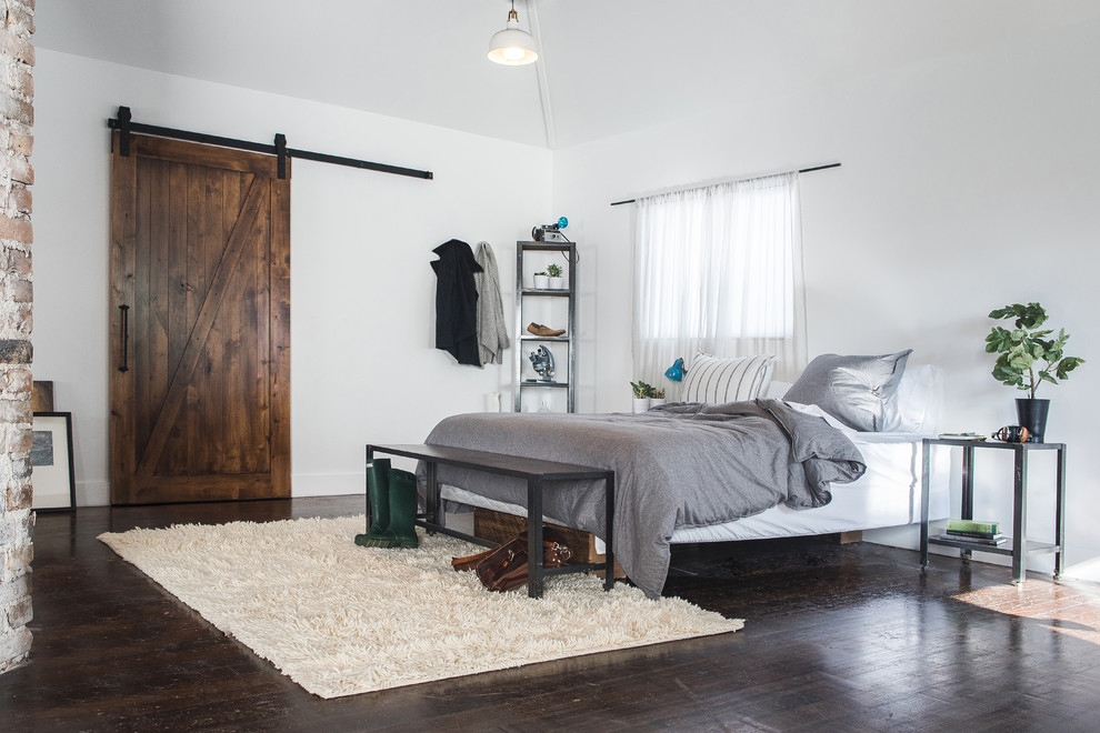 Foto di una camera da letto rustica con pareti bianche, pavimento in compensato e pavimento marrone