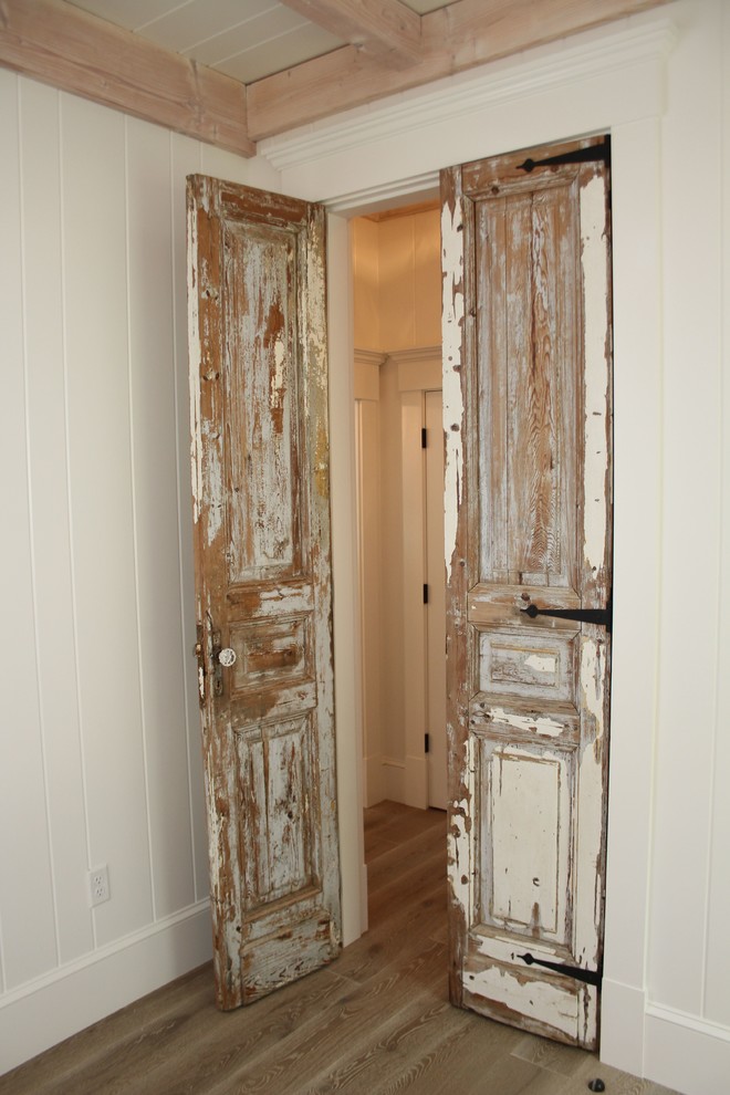 Foto di una camera matrimoniale boho chic di medie dimensioni con pareti bianche, pavimento in legno massello medio e pavimento marrone