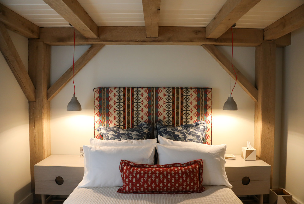 Ejemplo de habitación de invitados campestre de tamaño medio con paredes blancas, suelo de madera en tonos medios y suelo beige