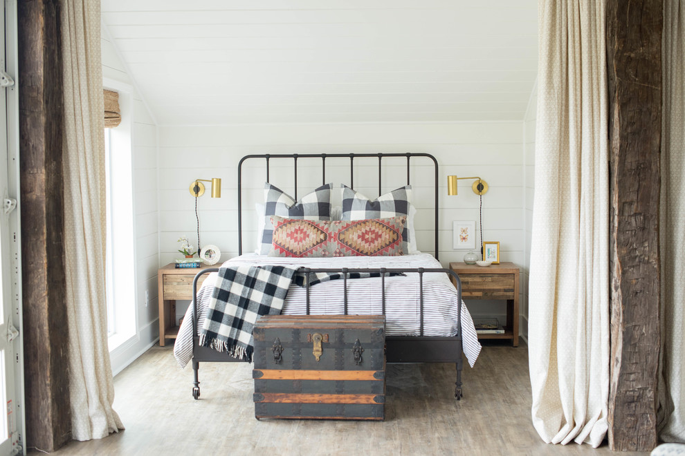 Immagine di una camera da letto country con pareti bianche e parquet chiaro