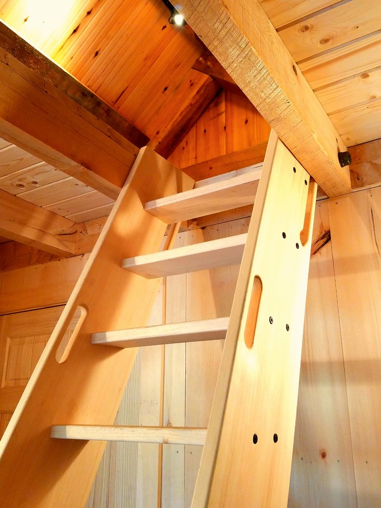 Ejemplo de dormitorio tipo loft campestre de tamaño medio con paredes beige y suelo de madera en tonos medios