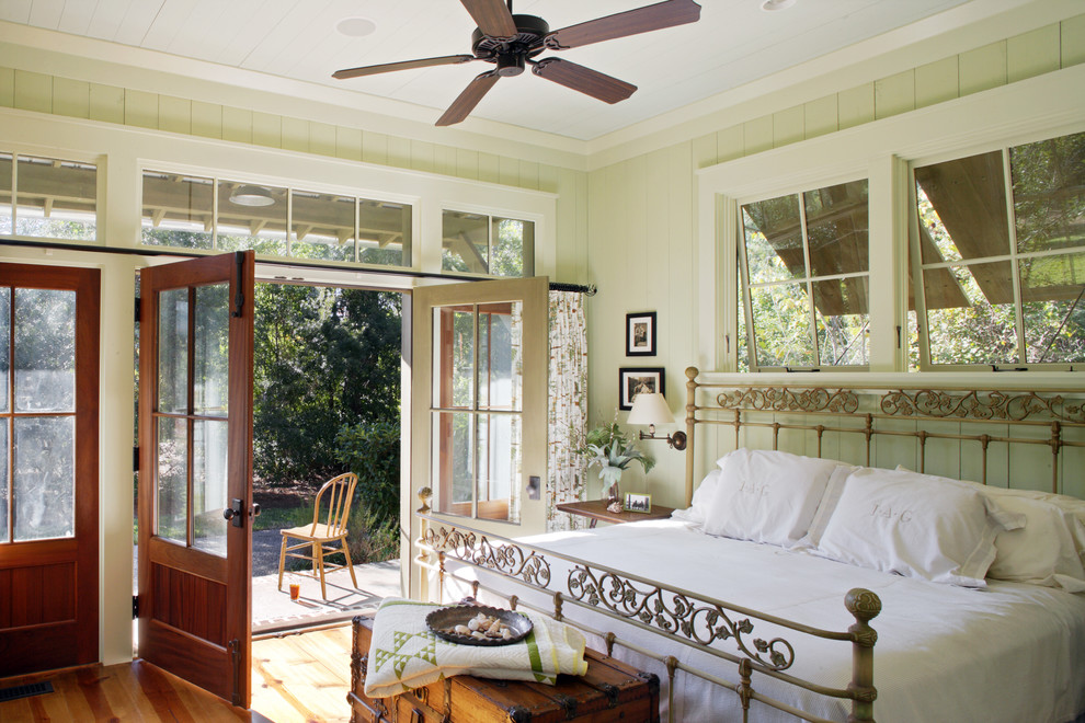 Ejemplo de dormitorio rústico con paredes verdes y suelo de madera en tonos medios