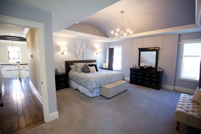 Photo of a large rural master bedroom in Chicago with grey walls, carpet, no fireplace and beige floors.