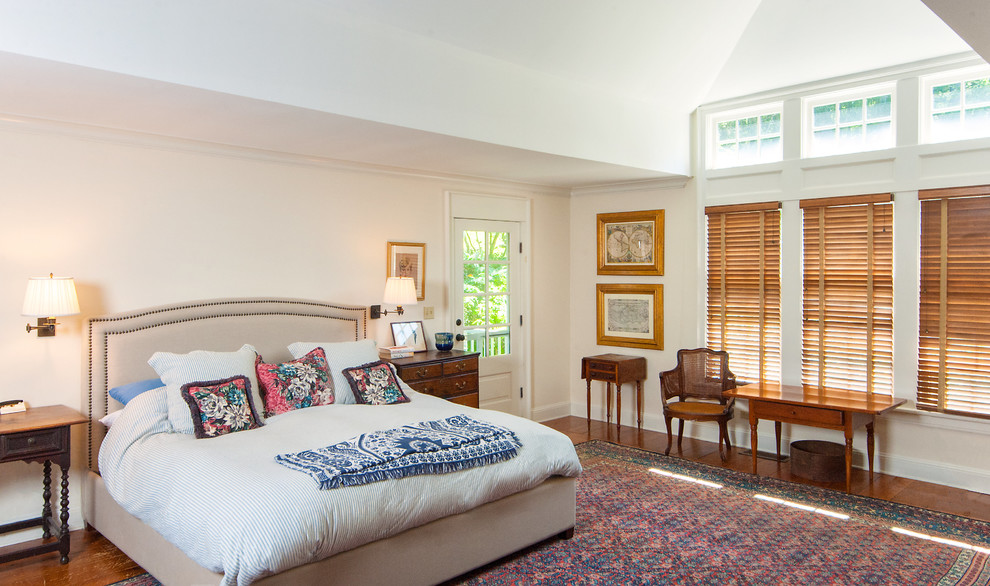 Kleines Country Schlafzimmer mit rosa Wandfarbe, braunem Holzboden, Kamin, Kaminumrandung aus Stein und braunem Boden in New York