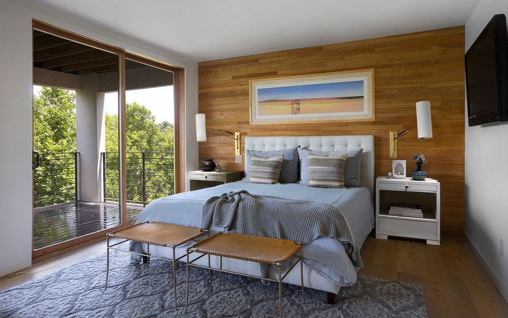 Inspiration pour une chambre parentale minimaliste de taille moyenne avec un mur blanc et un sol en bois brun.