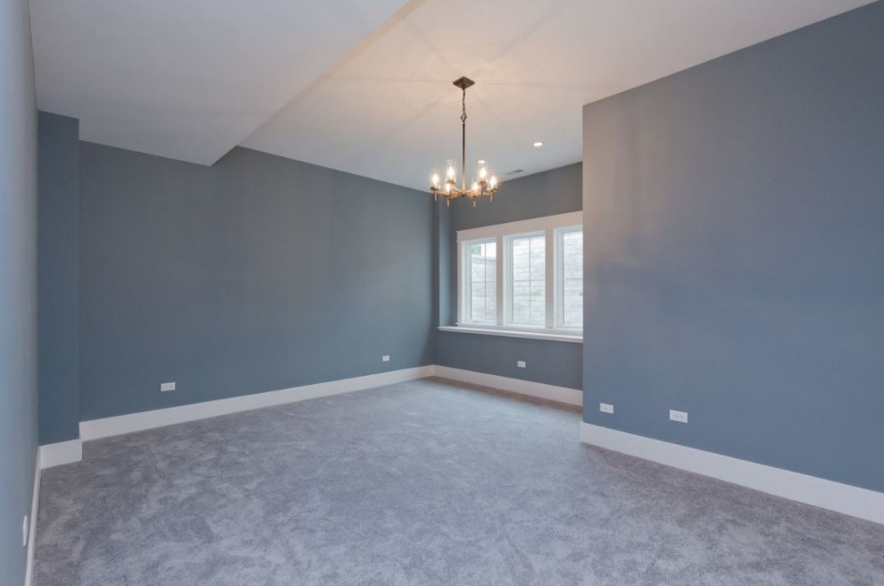 Photo of a large farmhouse bedroom in Chicago with blue walls, carpet and grey floors.