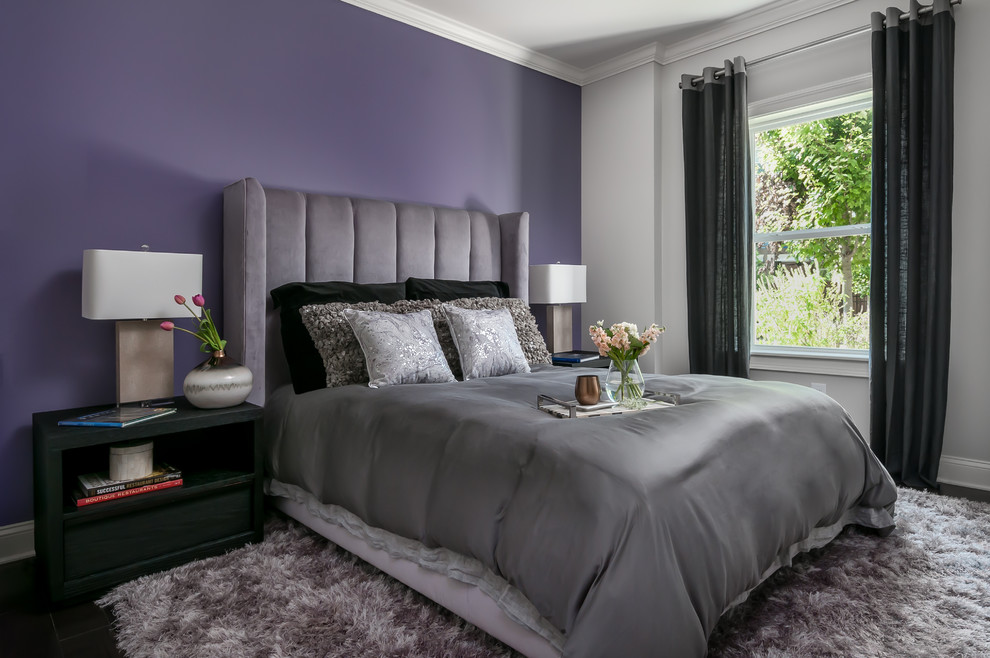 Medium sized modern guest bedroom with purple walls, dark hardwood flooring, a ribbon fireplace, a metal fireplace surround and brown floors.