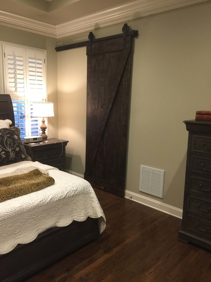 Imagen de dormitorio principal rural de tamaño medio sin chimenea con paredes beige y suelo de madera oscura