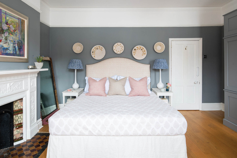 Источник вдохновения для домашнего уюта: хозяйская спальня в викторианском стиле с серыми стенами, светлым паркетным полом, печью-буржуйкой и фасадом камина из плитки