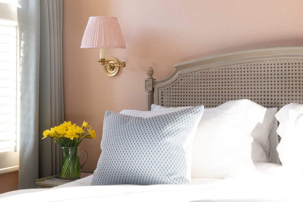 На фото: хозяйская спальня среднего размера в викторианском стиле с розовыми стенами, ковровым покрытием, стандартным камином, фасадом камина из камня и бежевым полом с