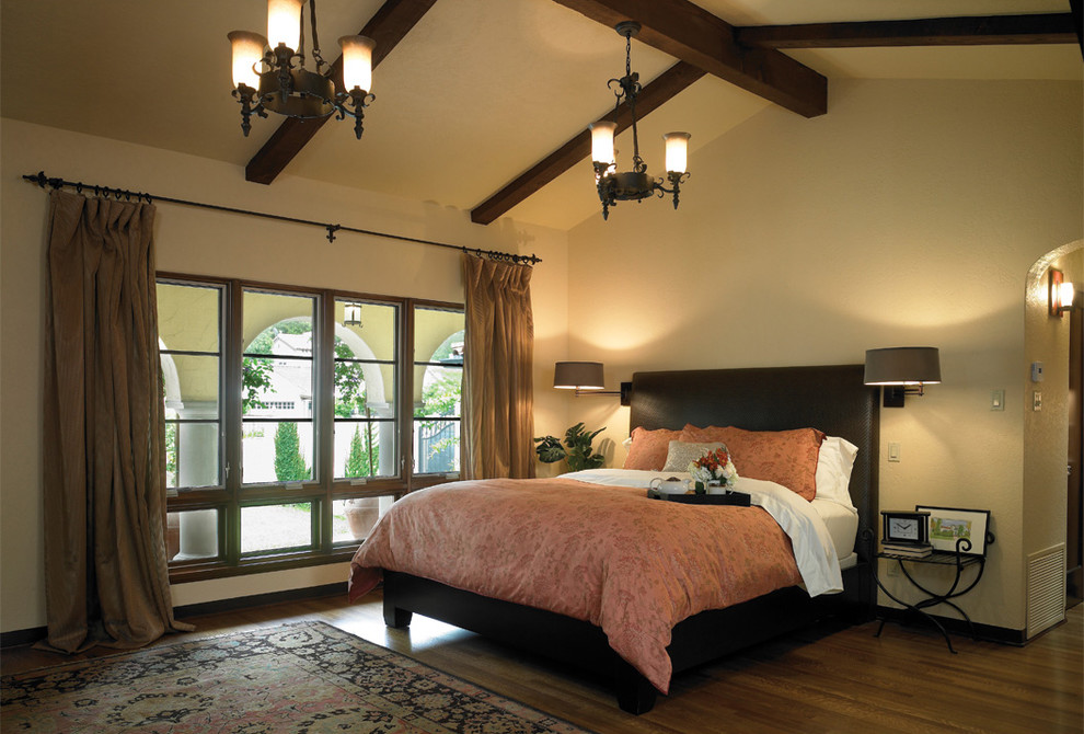 Bild på ett medelhavsstil sovrum, med beige väggar och mörkt trägolv