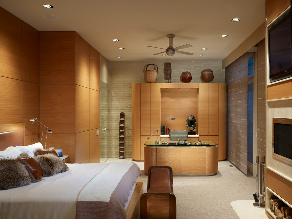 На фото: хозяйская спальня в современном стиле с ковровым покрытием, горизонтальным камином и фасадом камина из металла с