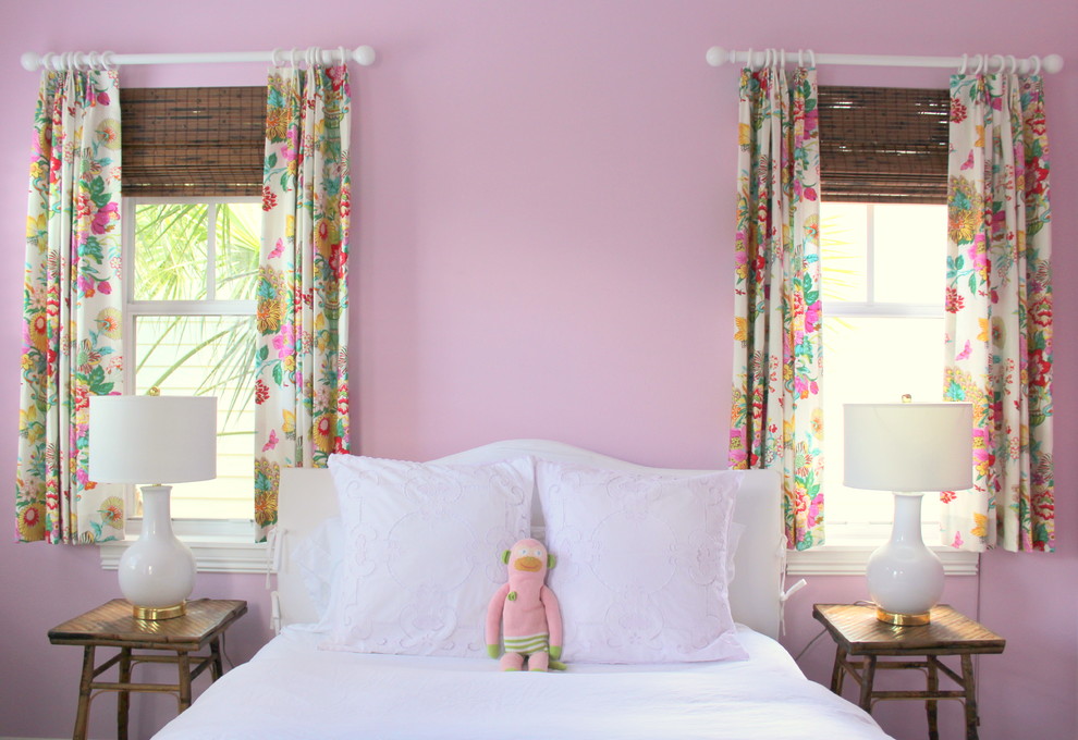 This is an example of a coastal guest bedroom in Miami with pink walls and dark hardwood flooring.