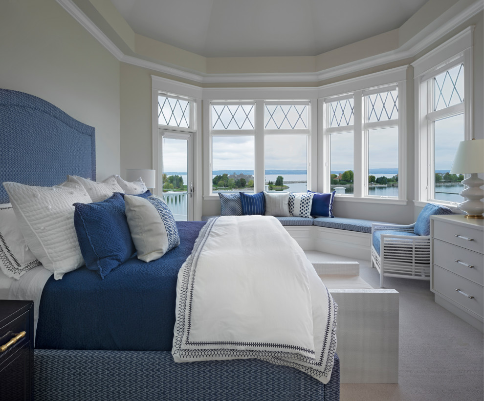 This is an example of a large coastal guest bedroom in Other with white walls, carpet and beige floors.