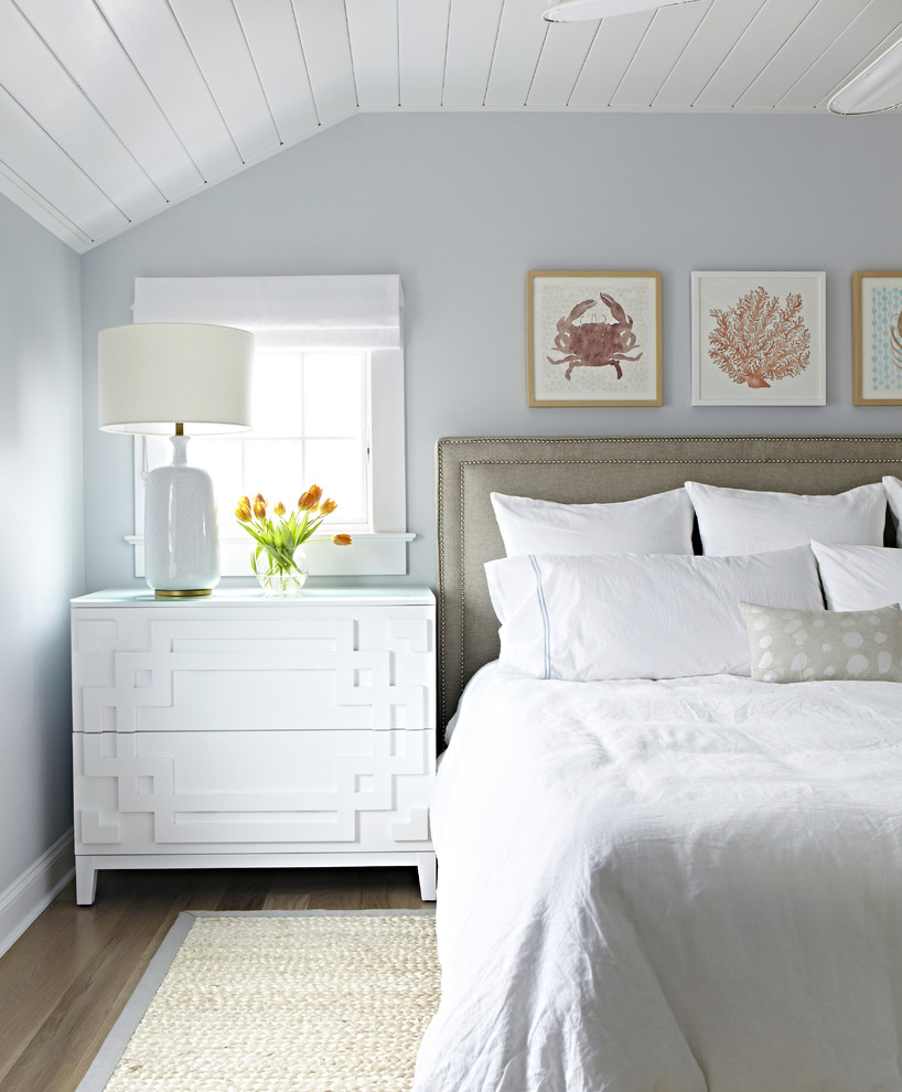 Ejemplo de dormitorio principal marinero de tamaño medio sin chimenea con paredes blancas y suelo de madera clara