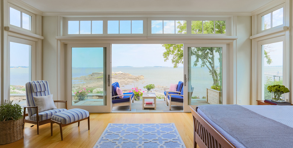 Large beach style master light wood floor and brown floor bedroom photo in Boston with white walls