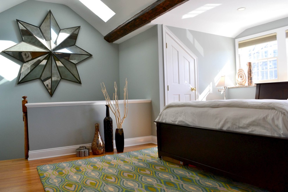 Modelo de dormitorio principal bohemio de tamaño medio con suelo de madera en tonos medios, paredes azules y techo inclinado