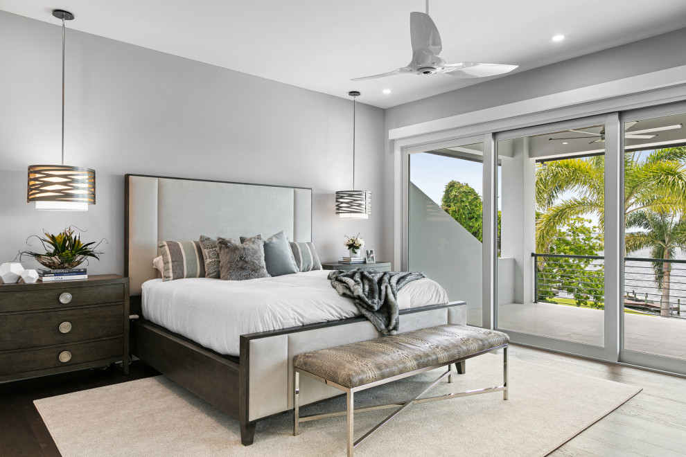 На фото: хозяйская спальня среднего размера в современном стиле с серыми стенами, темным паркетным полом и коричневым полом без камина
