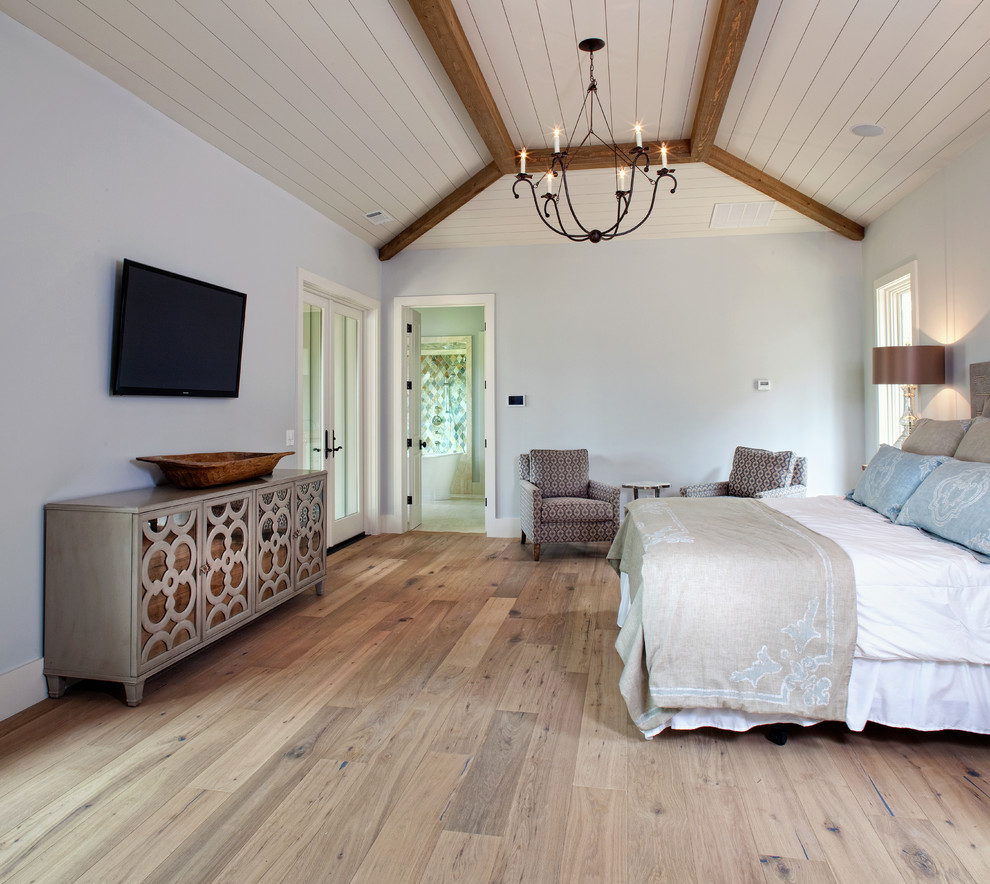Immagine di una grande camera matrimoniale stile marinaro con pareti bianche, pavimento in legno massello medio e pavimento marrone