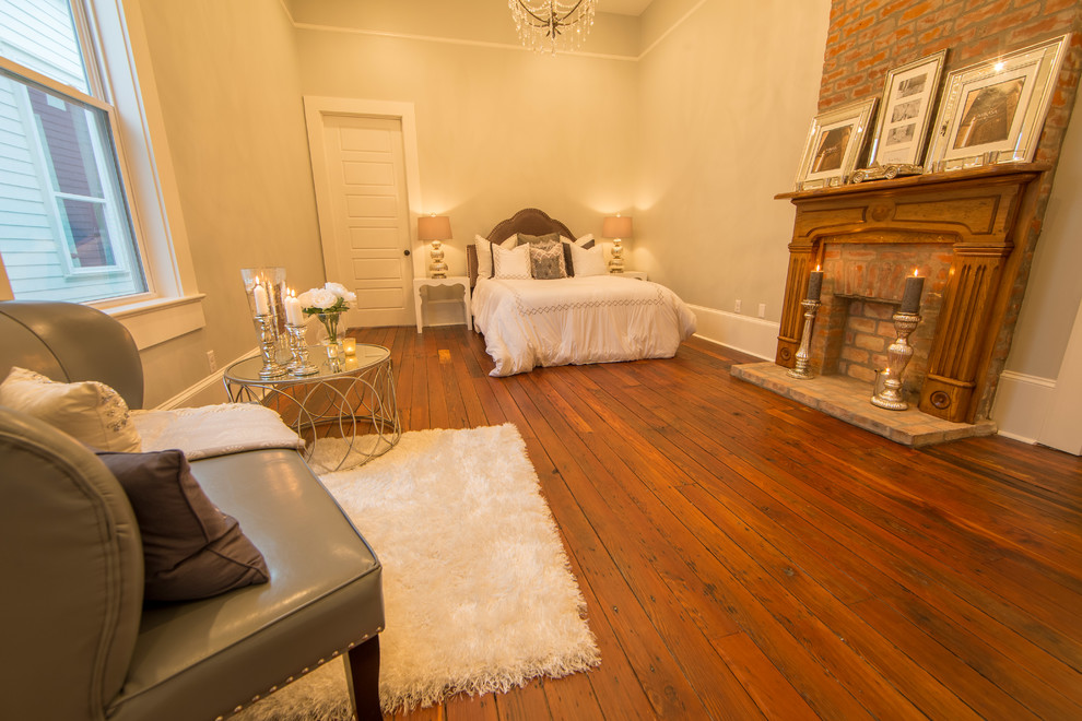 Aménagement d'une grande chambre parentale classique avec un mur beige, parquet foncé, une cheminée standard et un manteau de cheminée en brique.