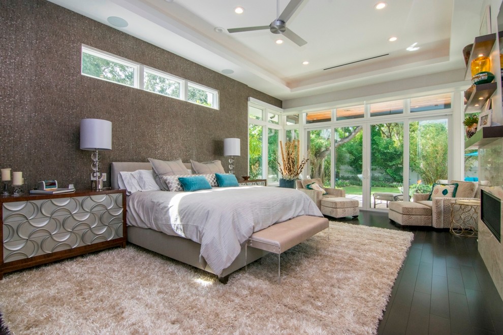 This is an example of a contemporary bedroom in Tampa with grey walls, dark hardwood flooring and a ribbon fireplace.