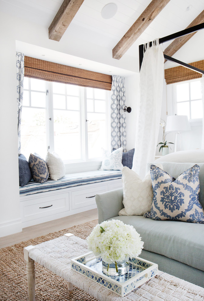 Imagen de dormitorio principal costero de tamaño medio con paredes blancas y suelo de madera clara