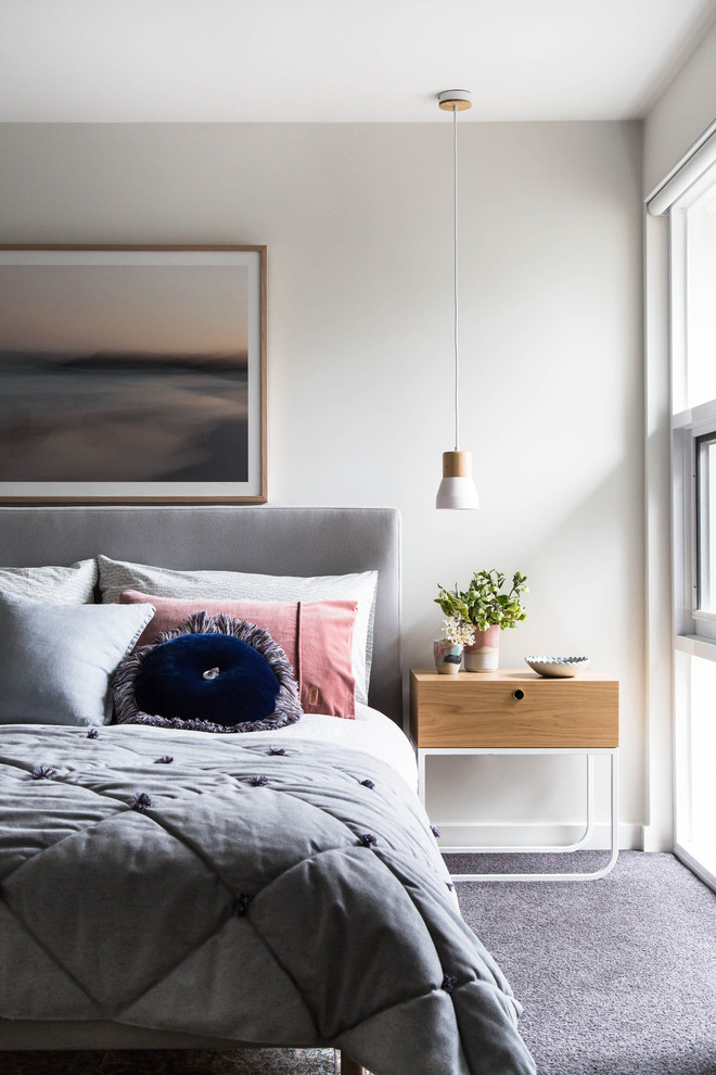 Scandinavian master bedroom in Melbourne with white walls, carpet and grey floors.