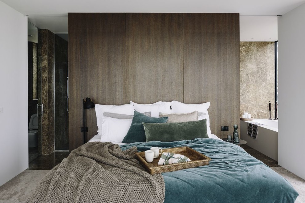 オークランドにあるコンテンポラリースタイルのおしゃれな主寝室 (茶色い壁、カーペット敷き、ベージュの床) のインテリア