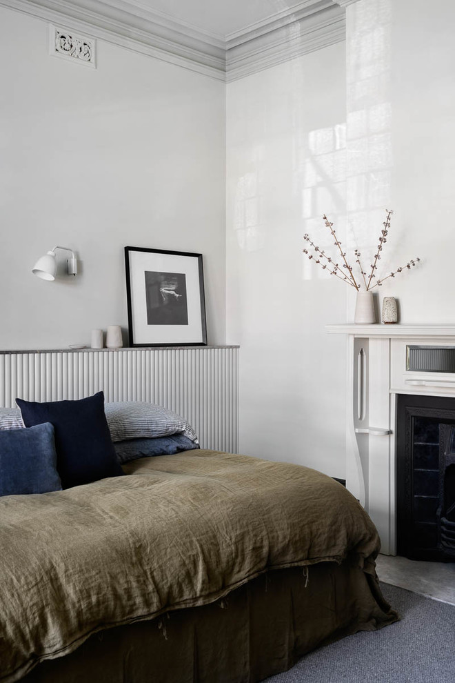 Cette photo montre une chambre avec moquette tendance avec un mur beige, une cheminée standard, un manteau de cheminée en métal et un sol gris.
