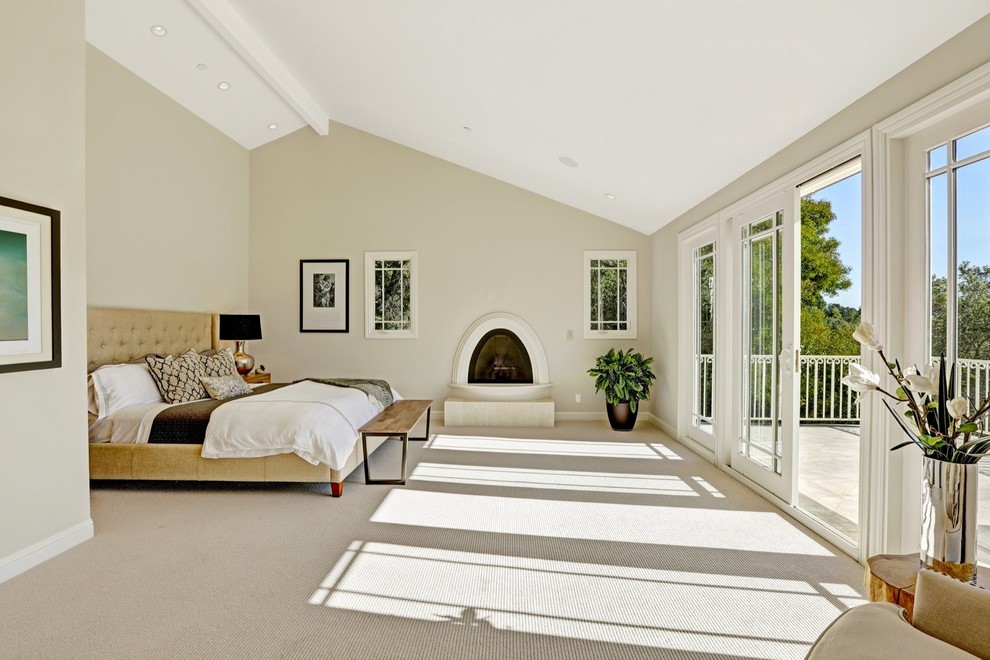 Modelo de dormitorio actual con paredes beige, moqueta y chimenea lineal