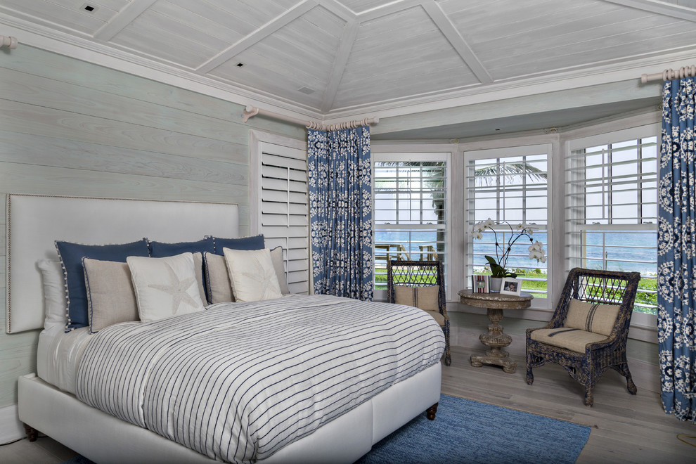 Ejemplo de dormitorio principal marinero de tamaño medio sin chimenea con paredes grises y suelo de madera clara