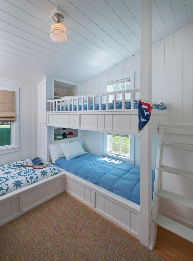 Idéer för ett maritimt sovrum, med vita väggar och mellanmörkt trägolv