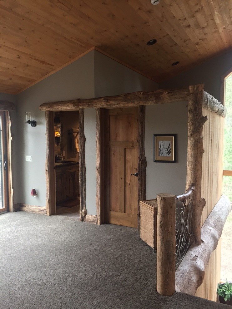 This is an example of a rustic mezzanine bedroom in Other with grey walls, carpet and grey floors.