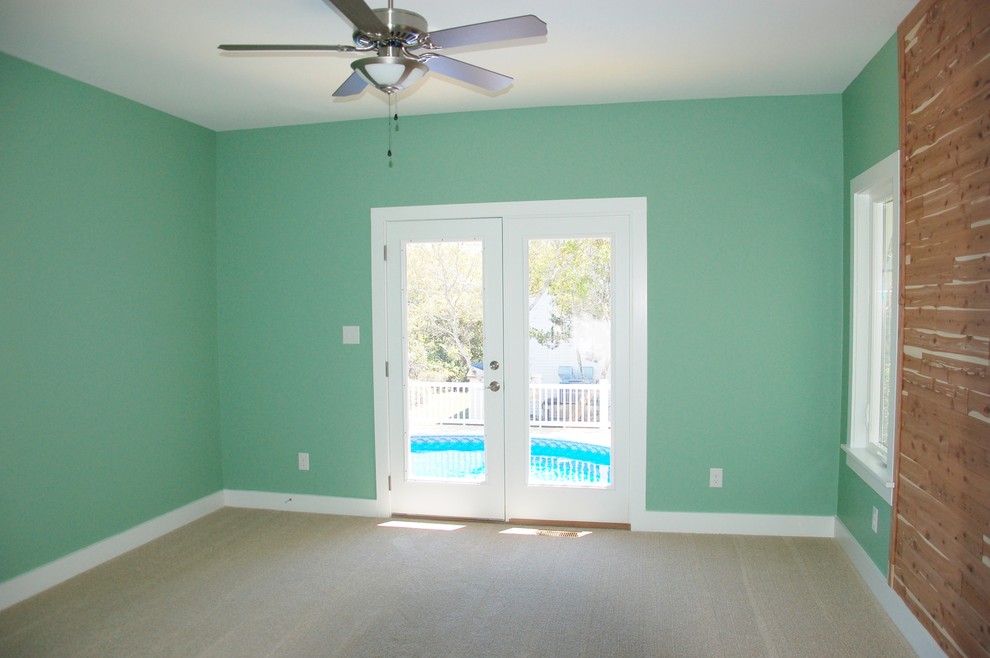 Cette photo montre une chambre bord de mer de taille moyenne avec un mur vert, aucune cheminée et un sol beige.