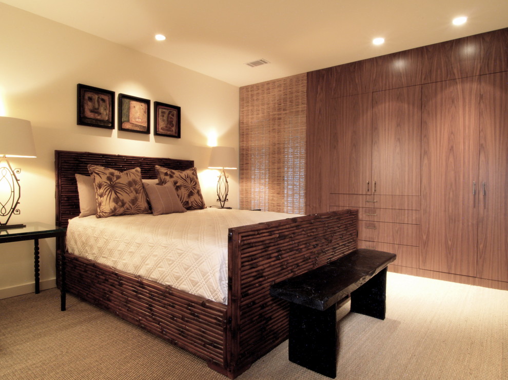 Immagine di una camera da letto tropicale con pareti beige e moquette