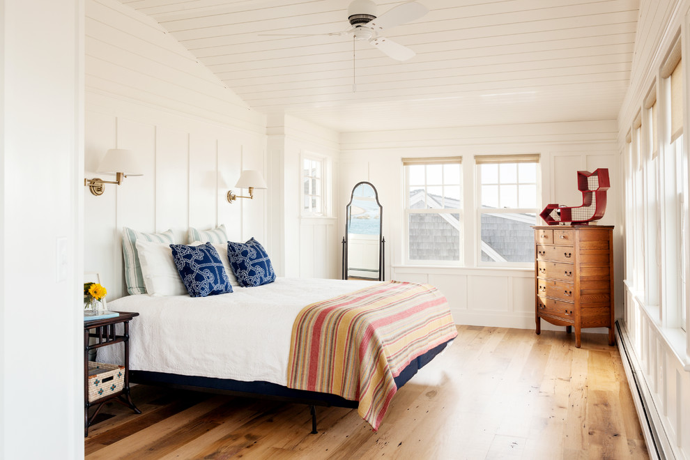 Пример оригинального дизайна: спальня в морском стиле с белыми стенами и паркетным полом среднего тона без камина