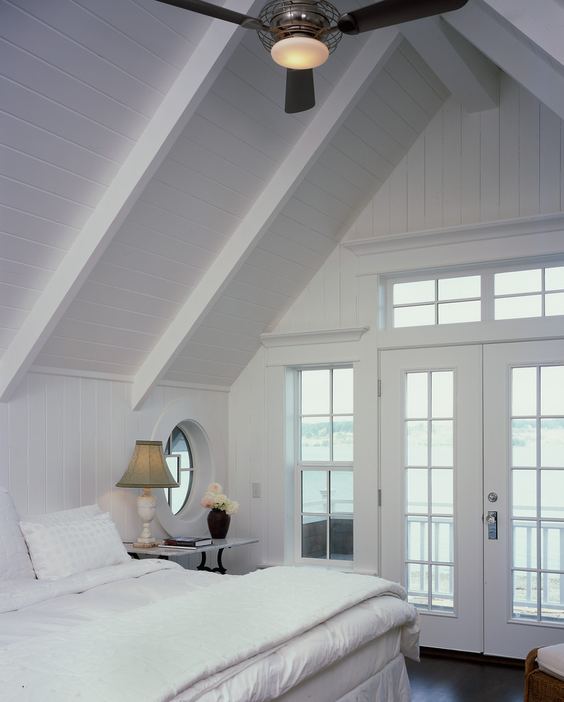 This is an example of a medium sized beach style guest bedroom in Seattle with white walls and dark hardwood flooring.